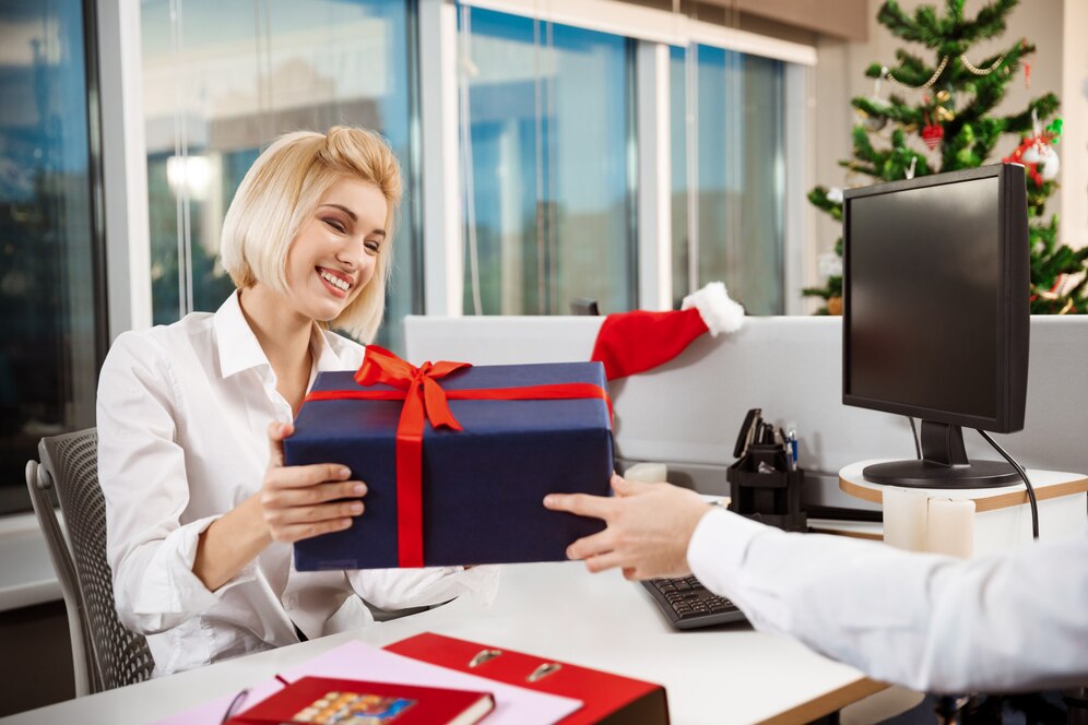 colleagues-celebrating-christmas-party-office-smiling-giving-presents_176420-7714.jpg