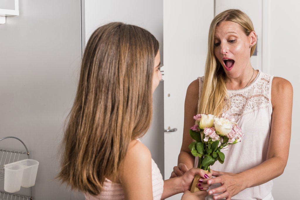 daughter-giving-flowers-to-amazed-mother.jpg