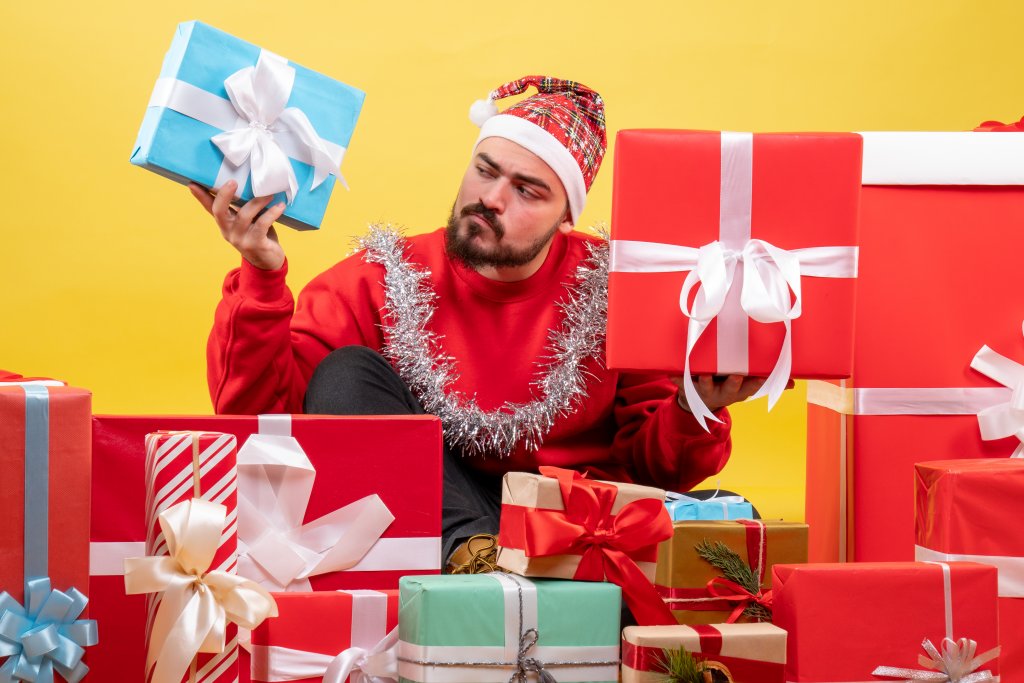 front-view-young-male-sitting-around-christmas-presents-on-yellow-background.jpg