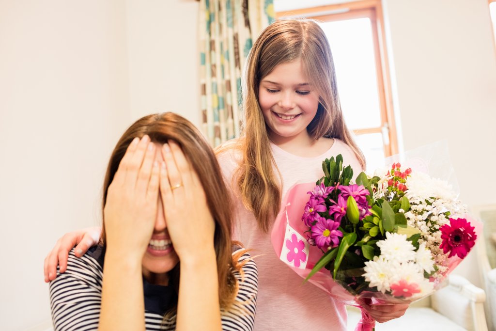 mother-covering-her-eyes-while-receiving-gift-from-daughter.jpg