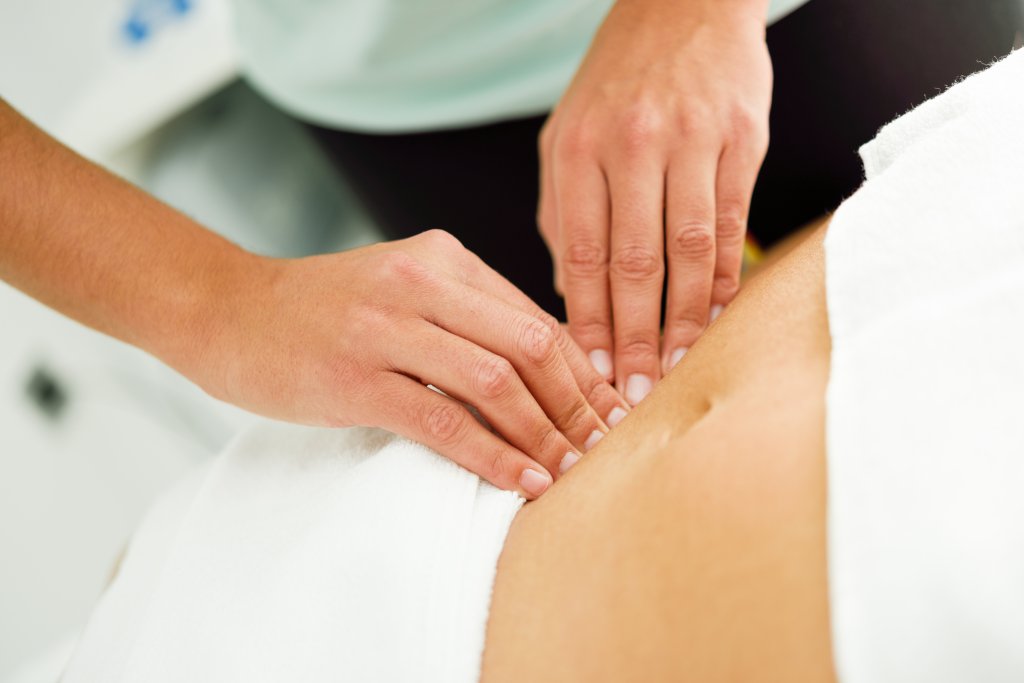 hands-massaging-female-abdomen-therapist-applying-pressure-on-belly.jpg