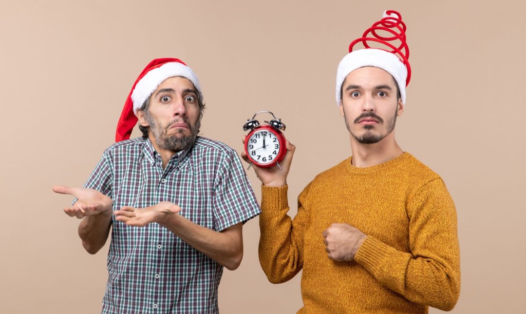 front-view-two-confused-men-one-holding-alarm-clock-beige-isolated-background.jpg