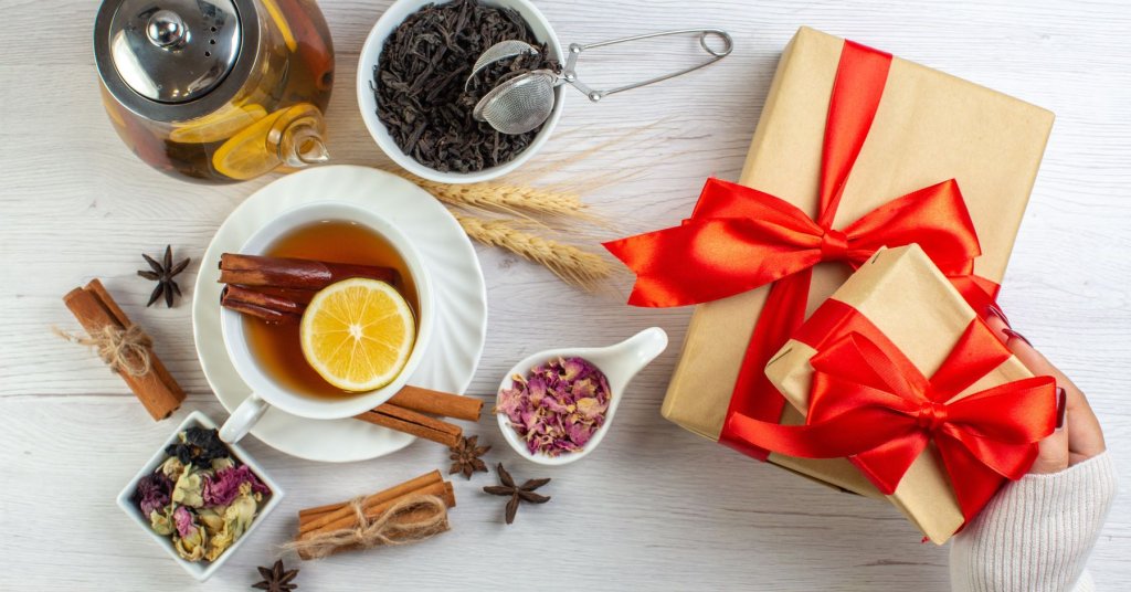 top-view-tea-break-with-cinnamon-lime-lemon-cup-pot-around-necessary-ingredients-gifts-with-red-ribbon-white-background2.jpg